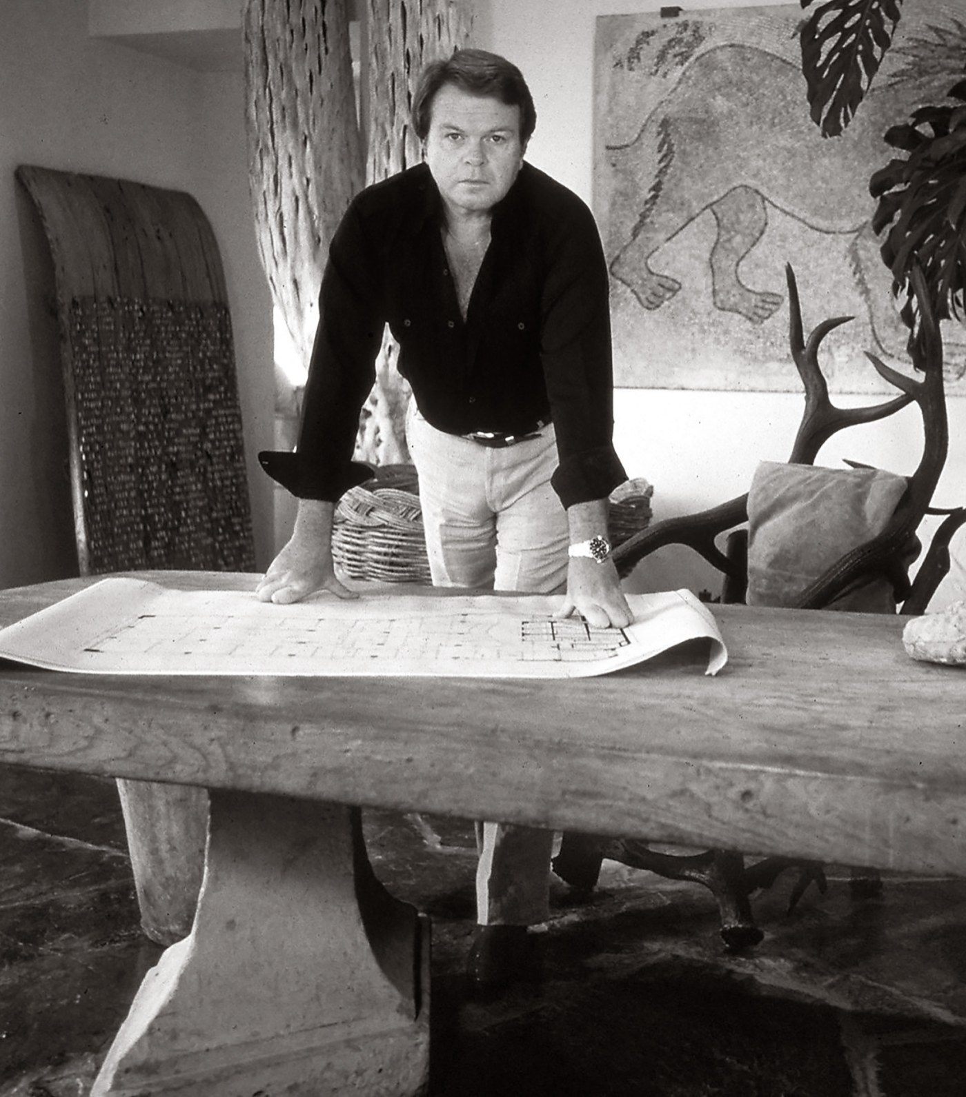 Michael Taylor standing over his iconic Diamond table